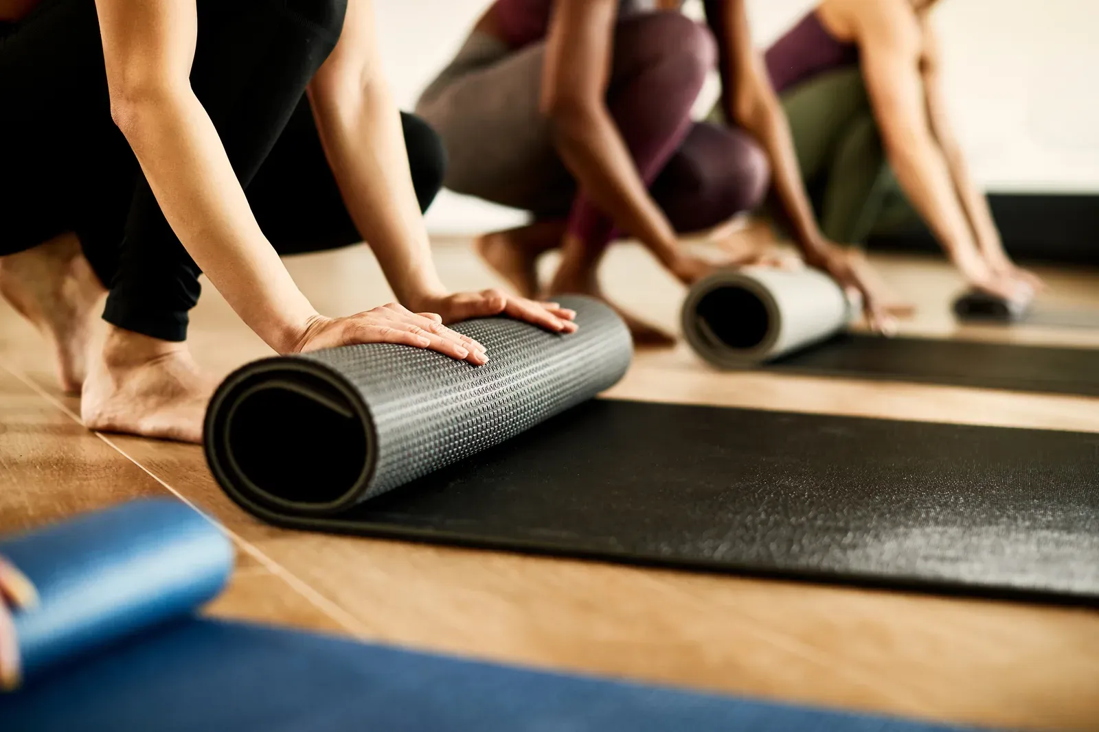 Athletic woman rolling up her mat after a group class at the health club