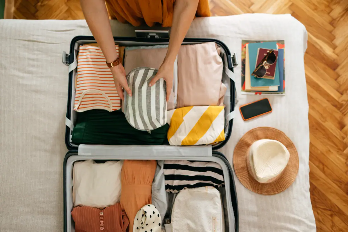 Packing a cosmetic bag into a suitcase before a work trip