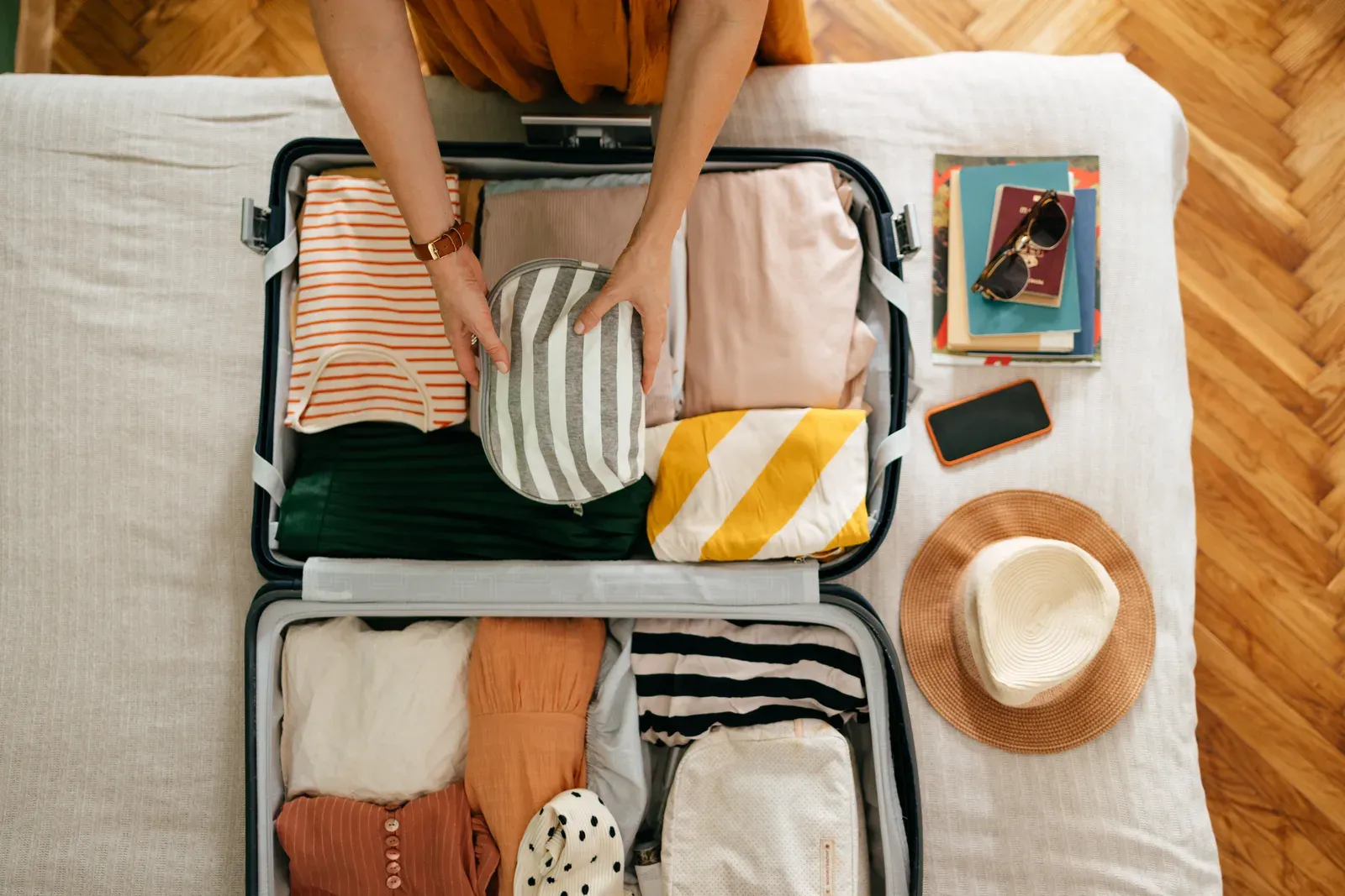 Packing a cosmetic bag into a suitcase before a work trip