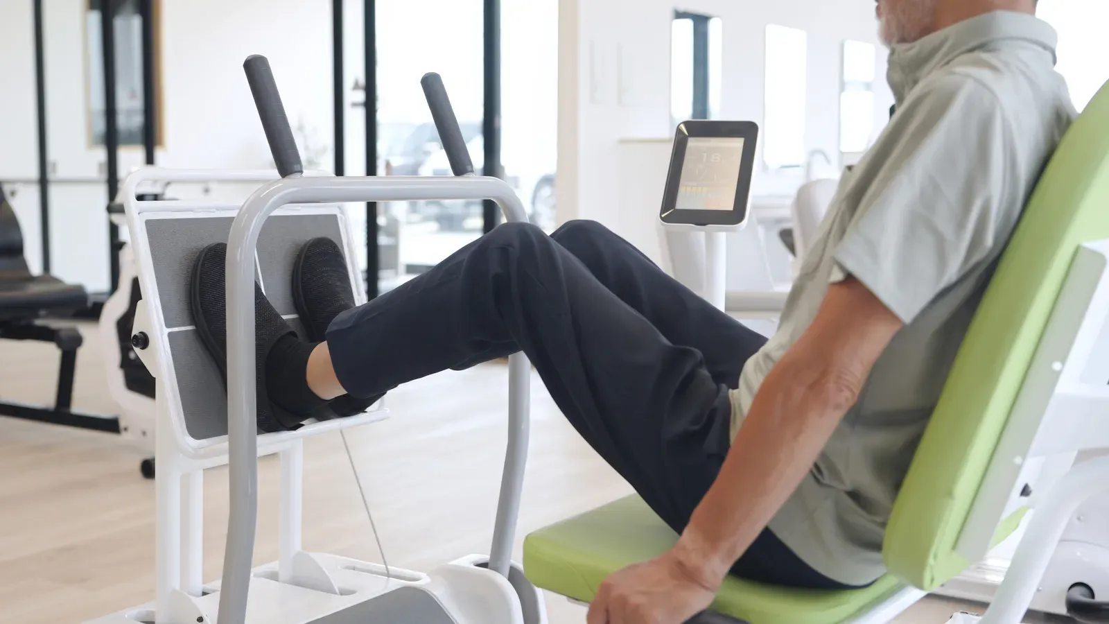 Coach guiding an older woman through a careful sit to stand exercise from a bench