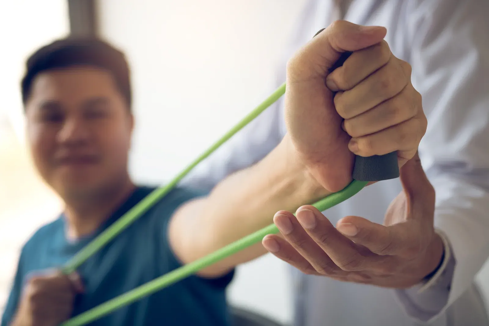 Woman performing a light resistance band shoulder exercise in a training room