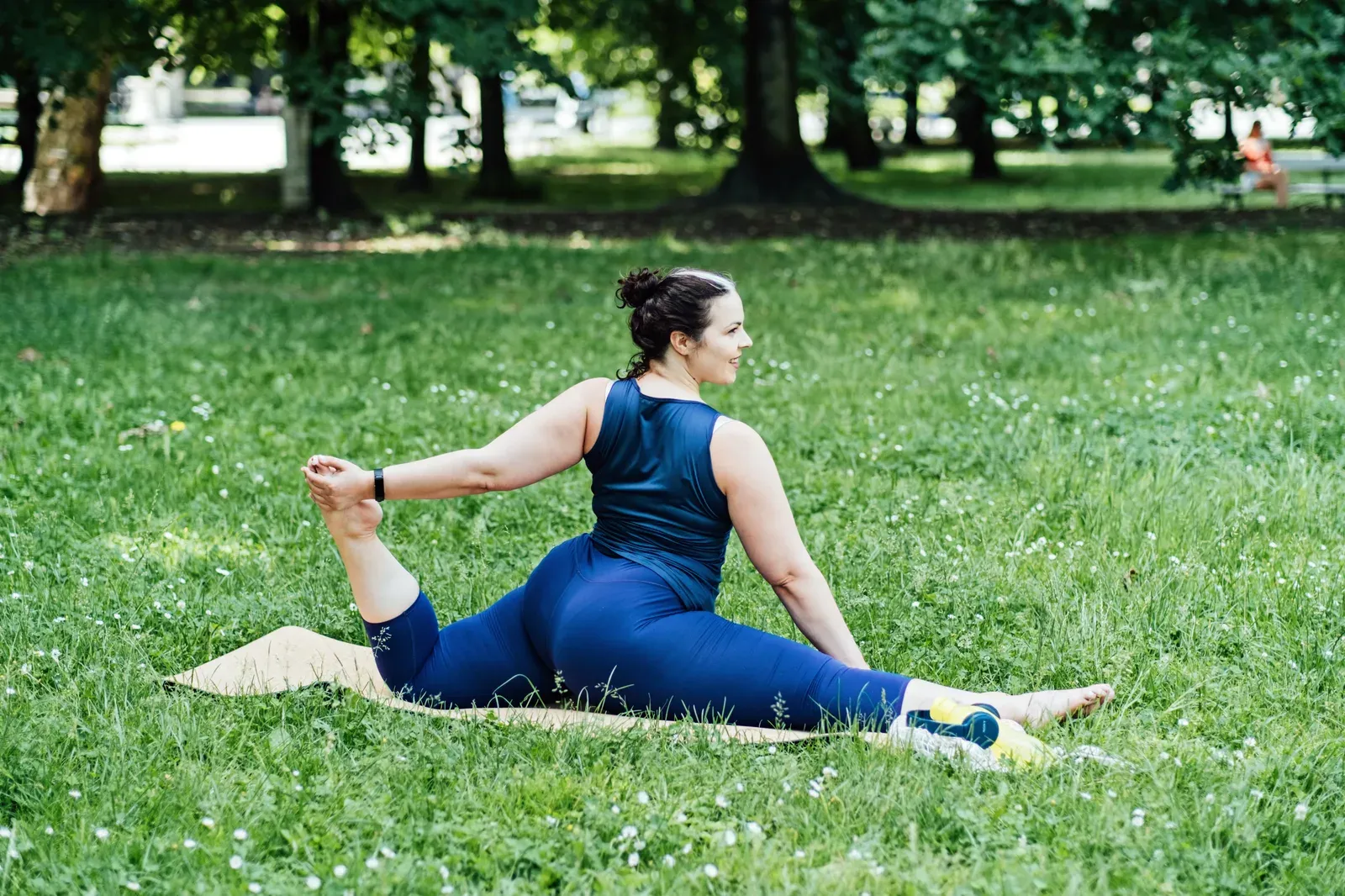 Middle aged man performing a box squat while a trainer watches his knee position