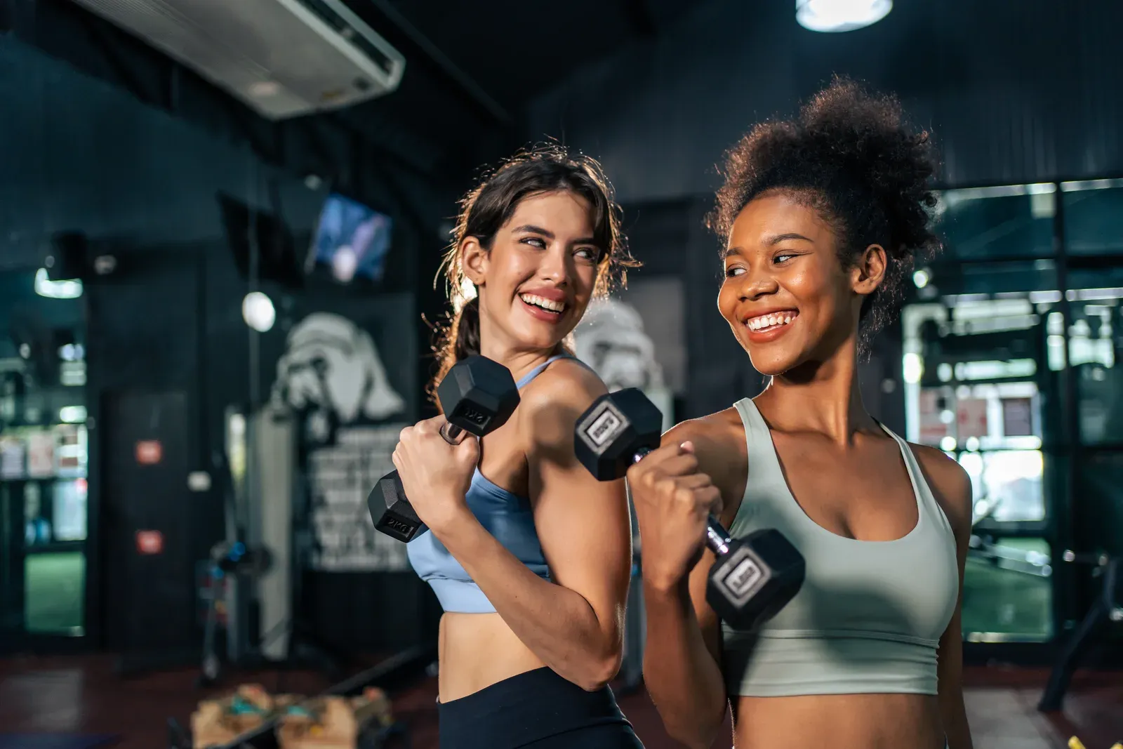 Young woman finishing a set of dumbbell rows in a quiet private training room