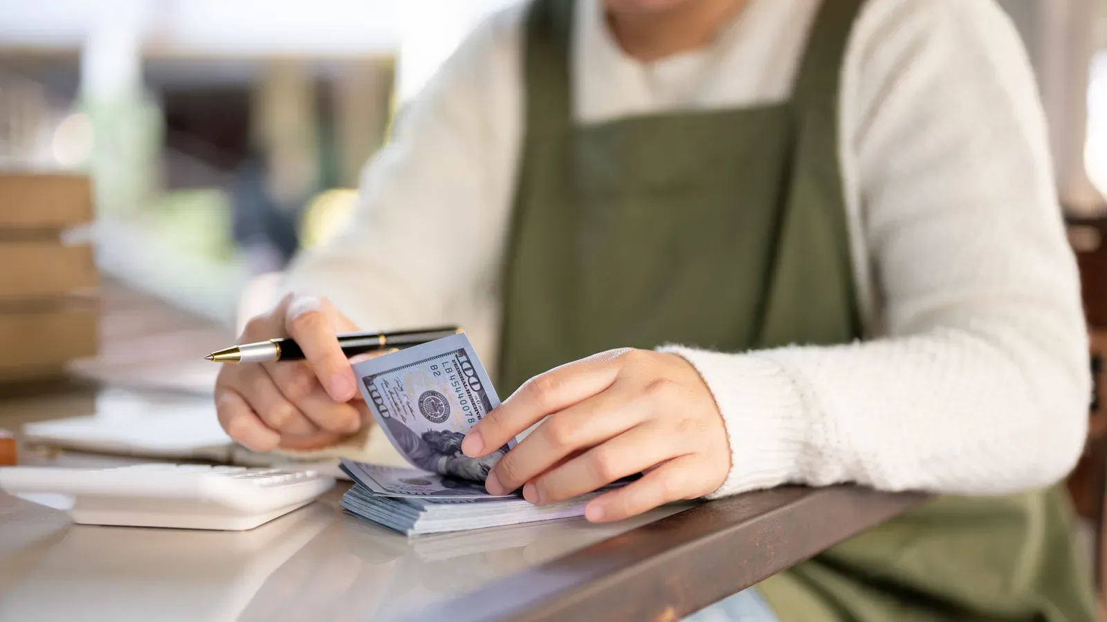 Female small business owner calculating her shop budget, a busy schedule that a trainer can plan around