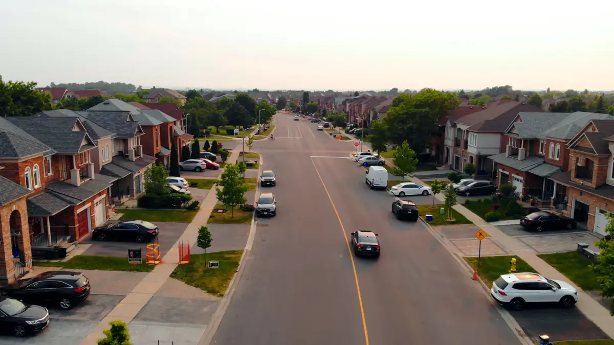 Wide residential street running through a newer subdivision of two story homes