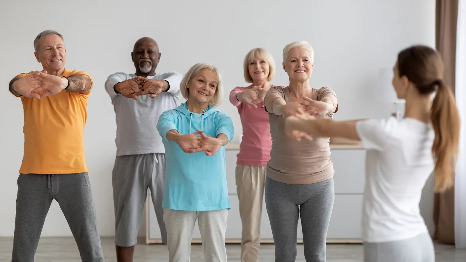 Elderly people in a fitness class training with an instructor, an active routine for retired men