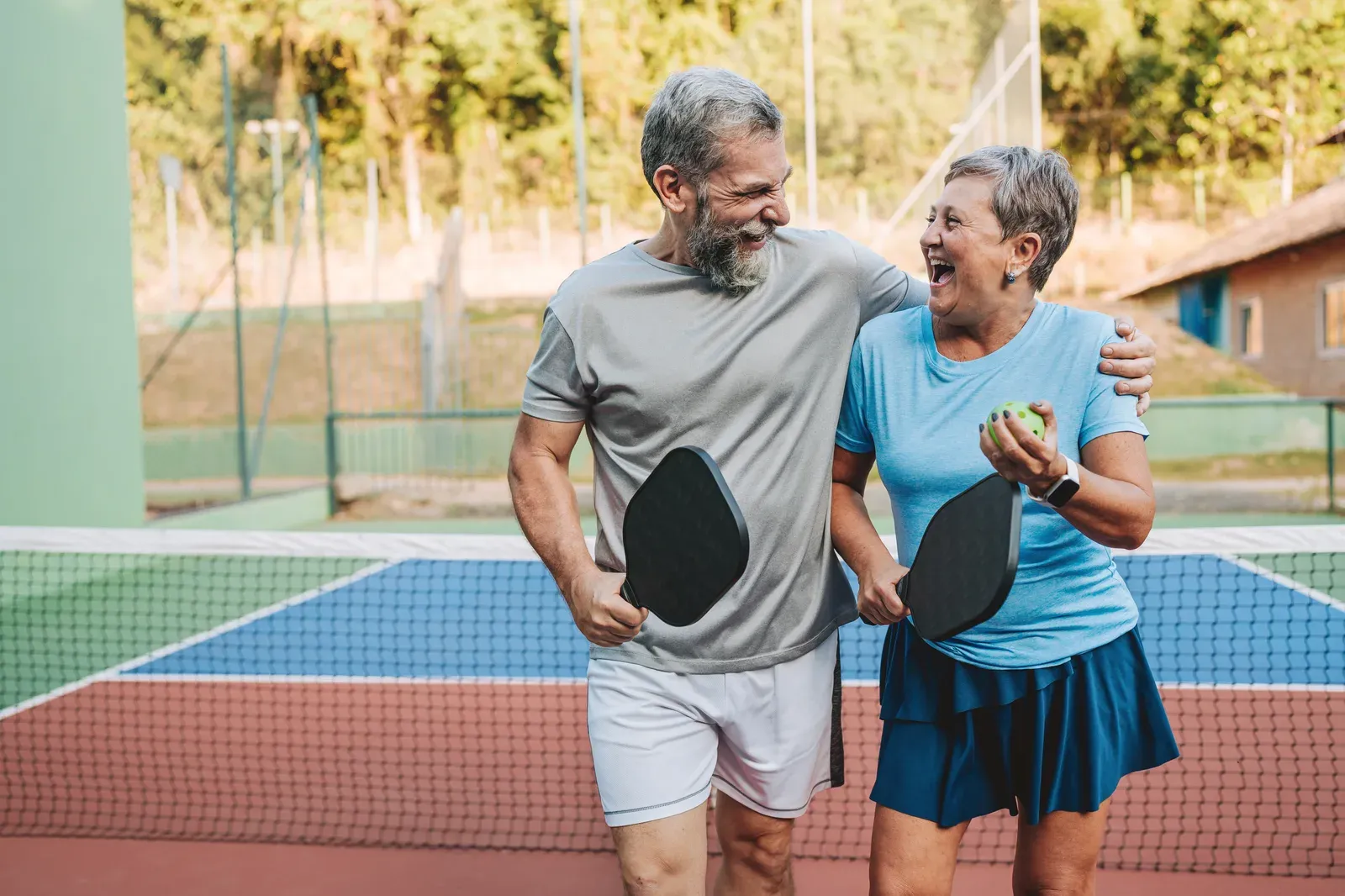 A player over 50 lunging for a shot on an indoor pickleball court