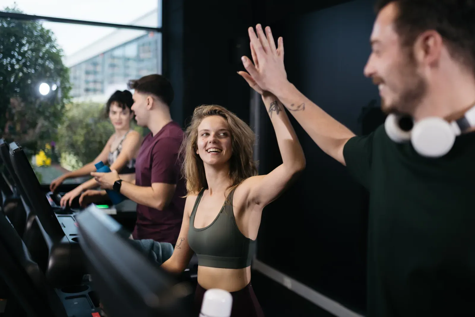 Group of friends smiling while exercising together at a fitness center, a shared session split among them