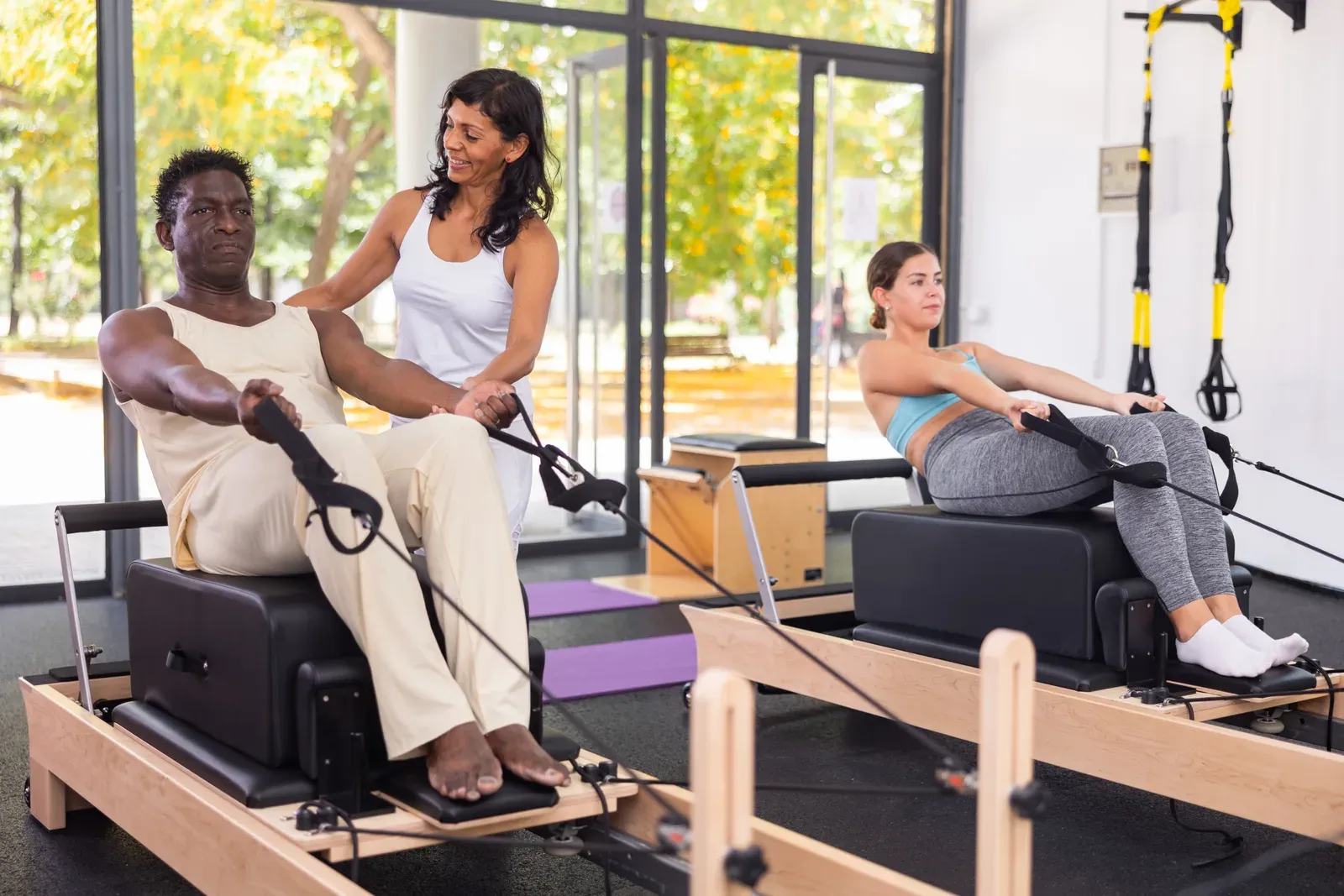 A woman performing controlled core work under the guidance of an instructor