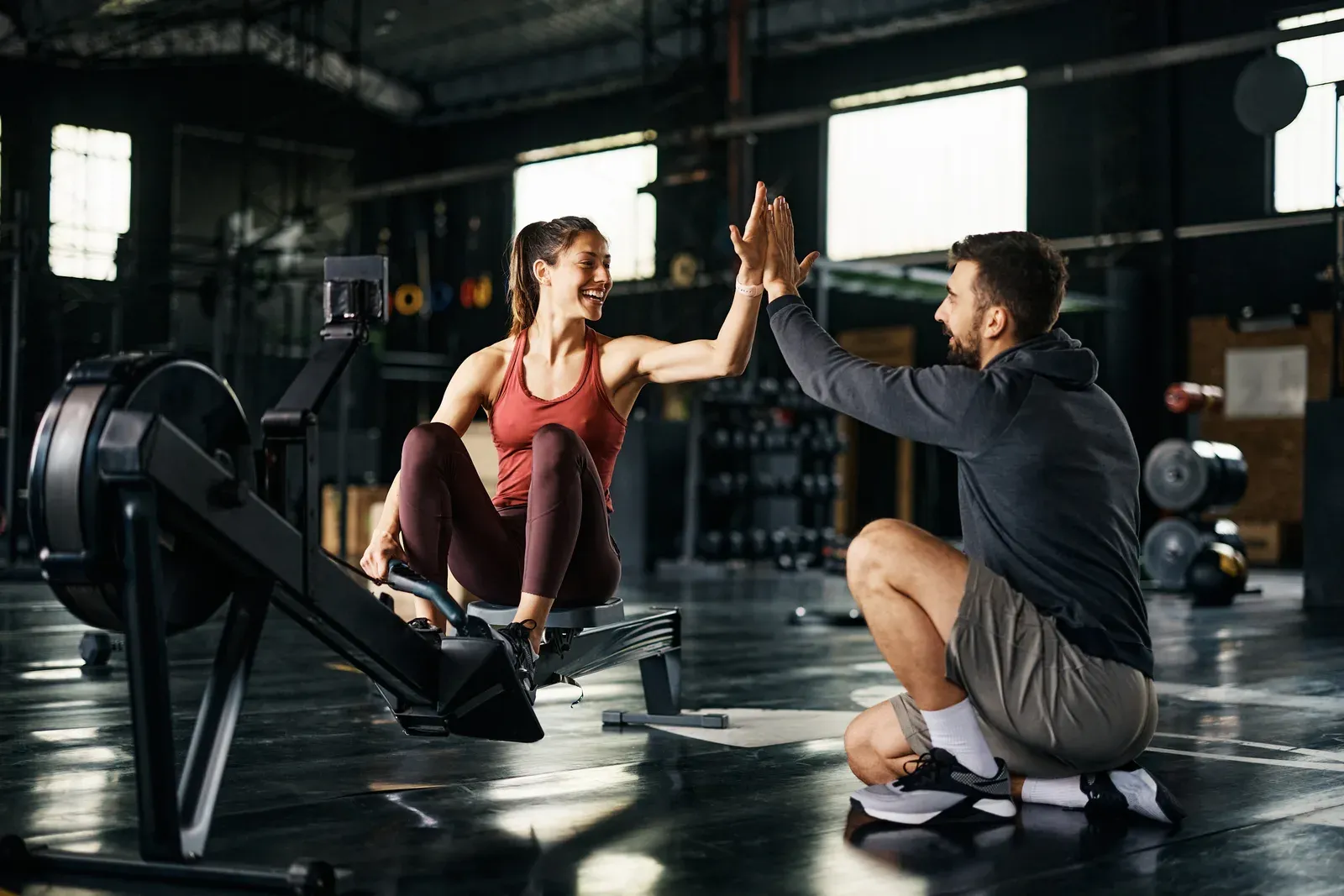 Athlete mid drive on a rowing machine during an indoor cardio workout