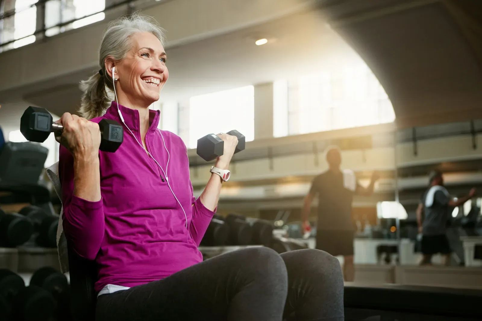 Older adult lifting weights with a smile, proof it is never too late