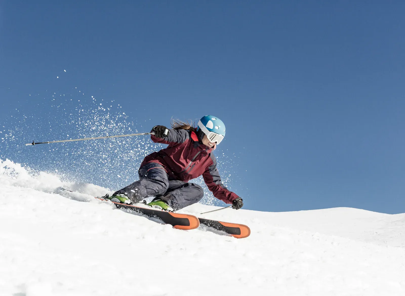 A skier carving a turn on a groomed downhill run