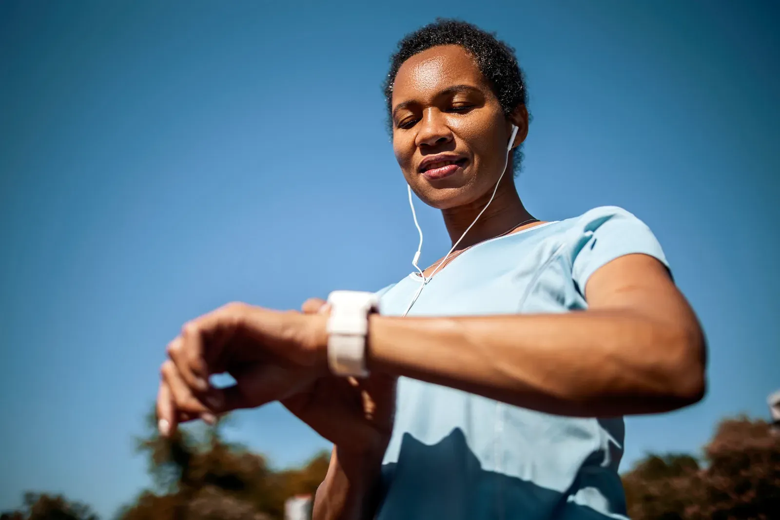 Smiling woman checking her heart rate after a training session