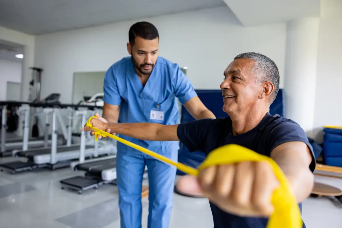 Man working through physical therapy exercises with a resistance stretch band