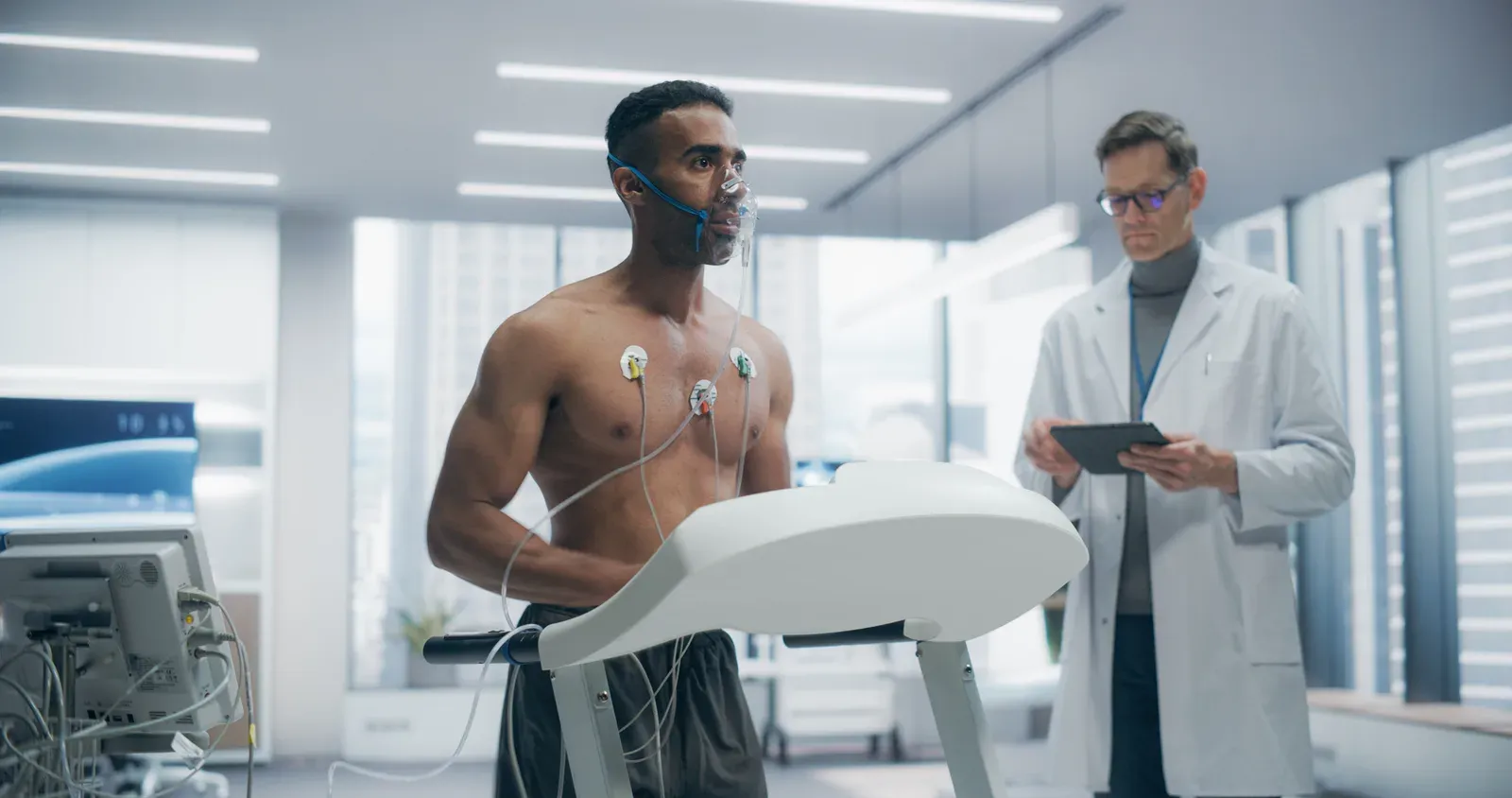 Mature man checking a heart rate monitor watch between exercises in a gym