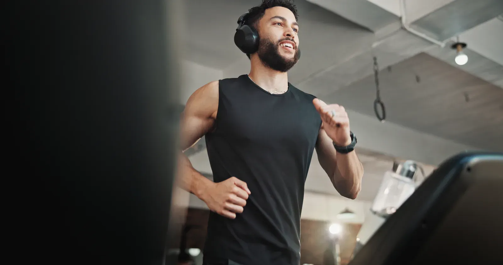 Man with headphones running on a treadmill at the gym, a daily cardio session to plan retirement around