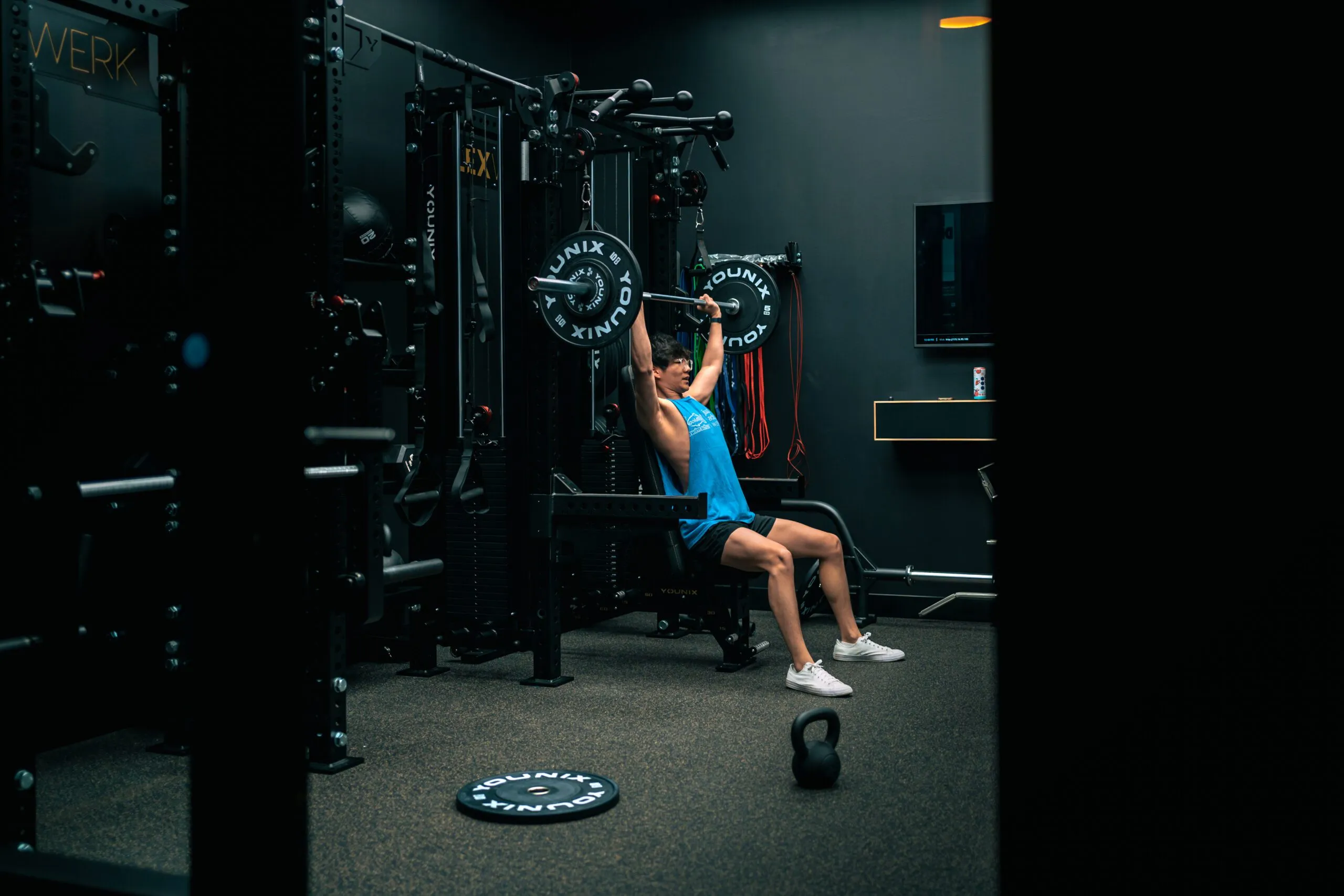 A client pressing a barbell on the rack inside a FlexSpace Standard suite