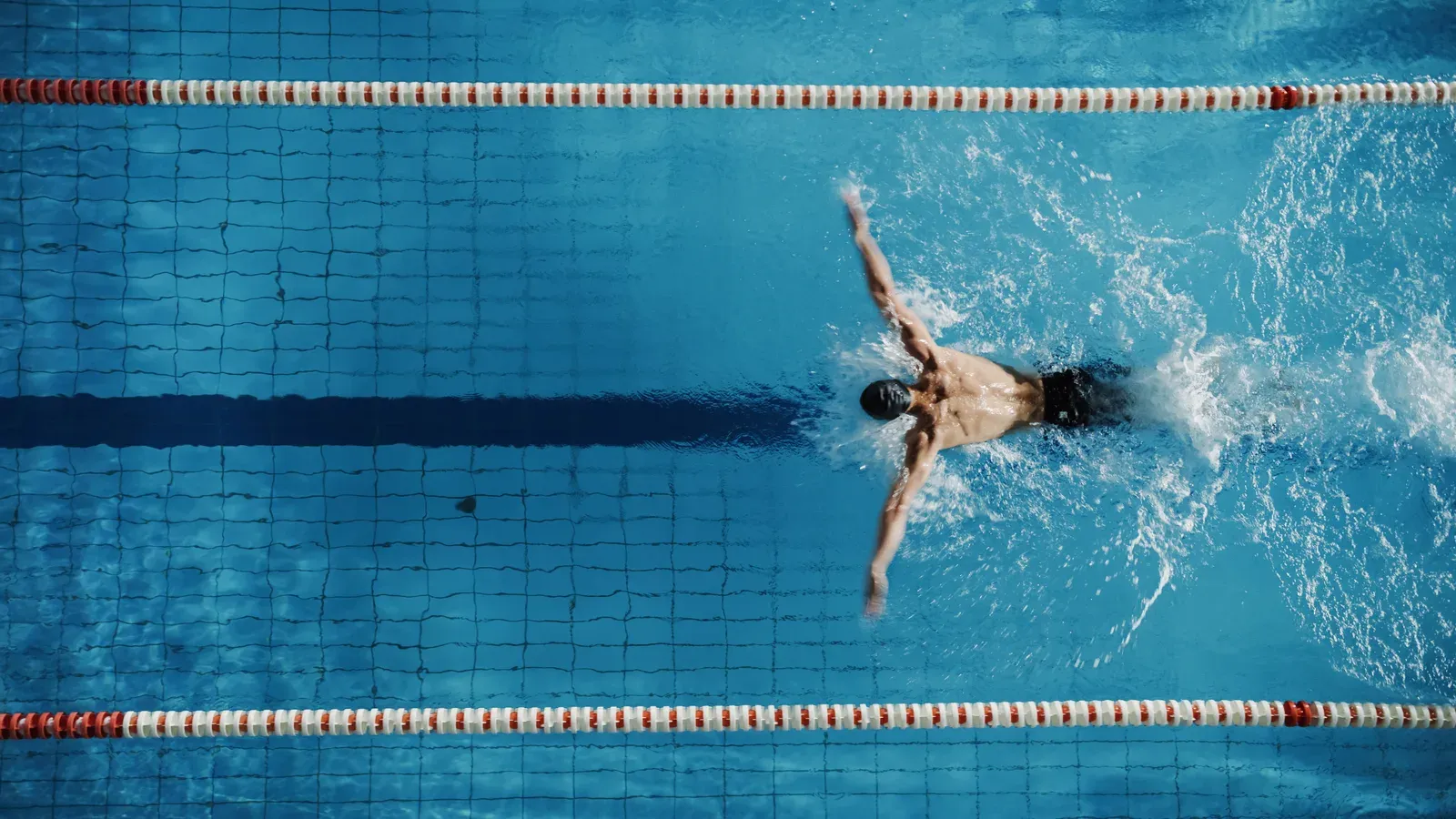 Swimmer mid-stroke in a lane, arm extended through the pull