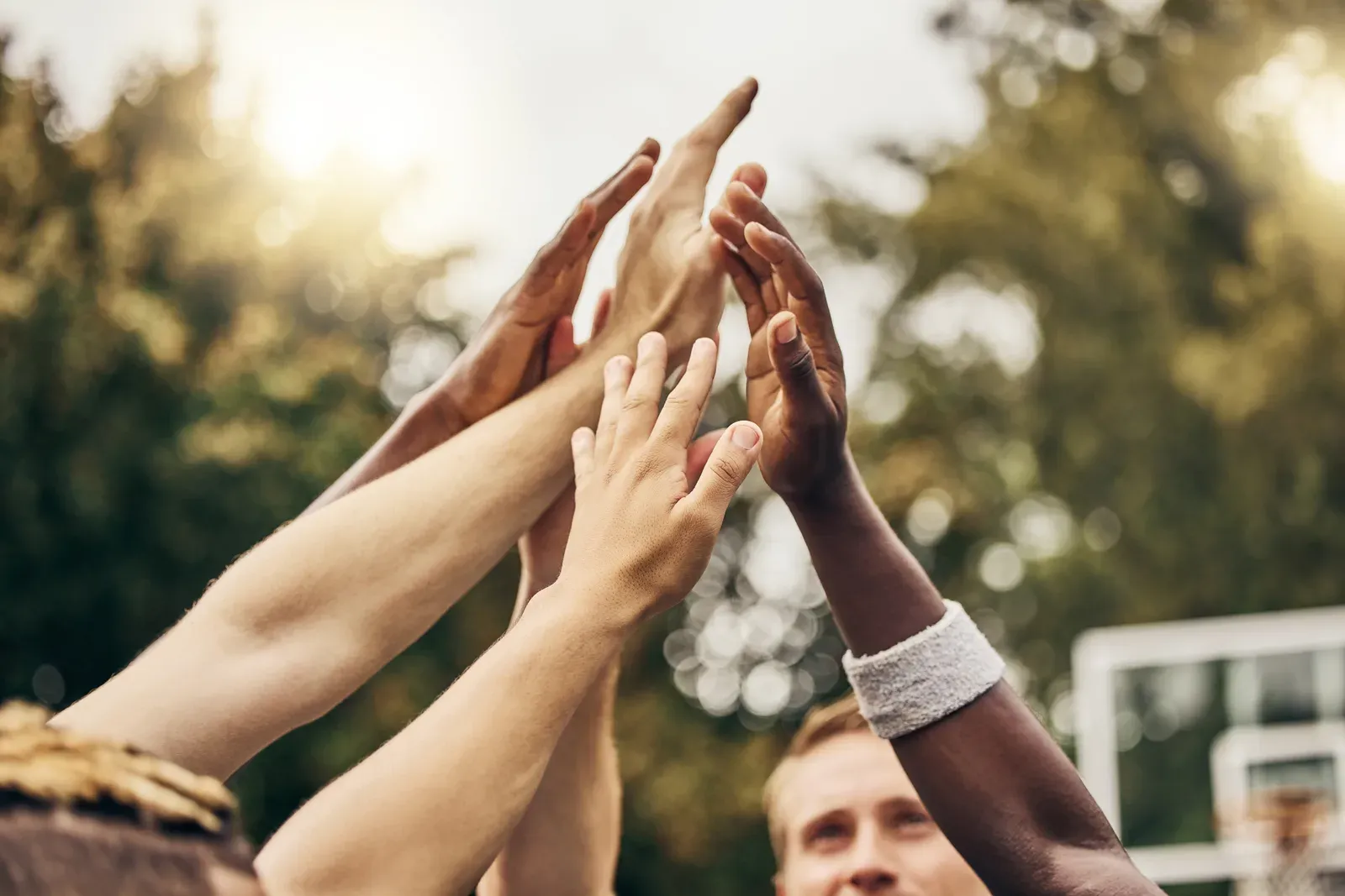 Four coworkers sharing a fist bump after finishing a workout together