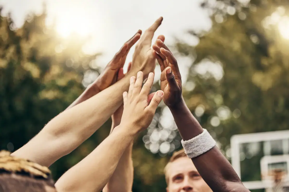 Four coworkers sharing a fist bump after finishing a workout together