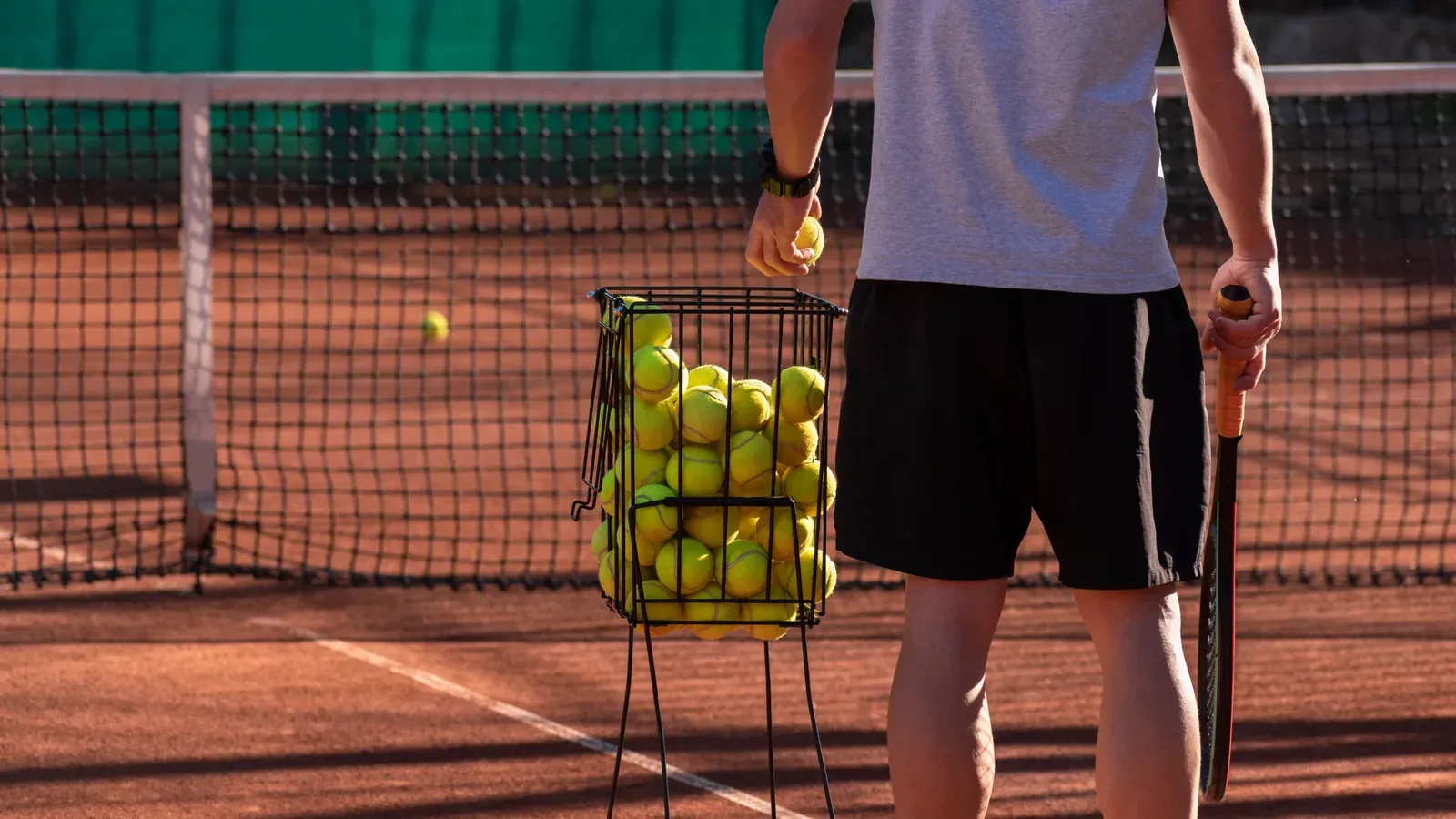 Tennis player exploding off the baseline toward a wide forehand during a training session