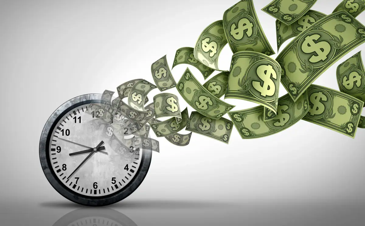 Clock paired with money, the time is money idea behind hourly rates