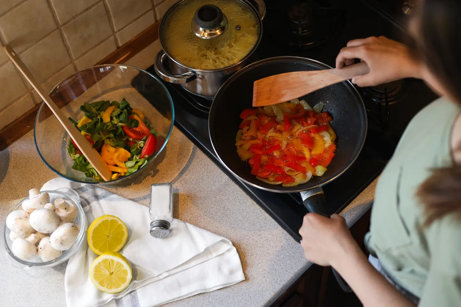 Cooking fresh vegetables in a frying pan, one of the nutrition habits that supports training