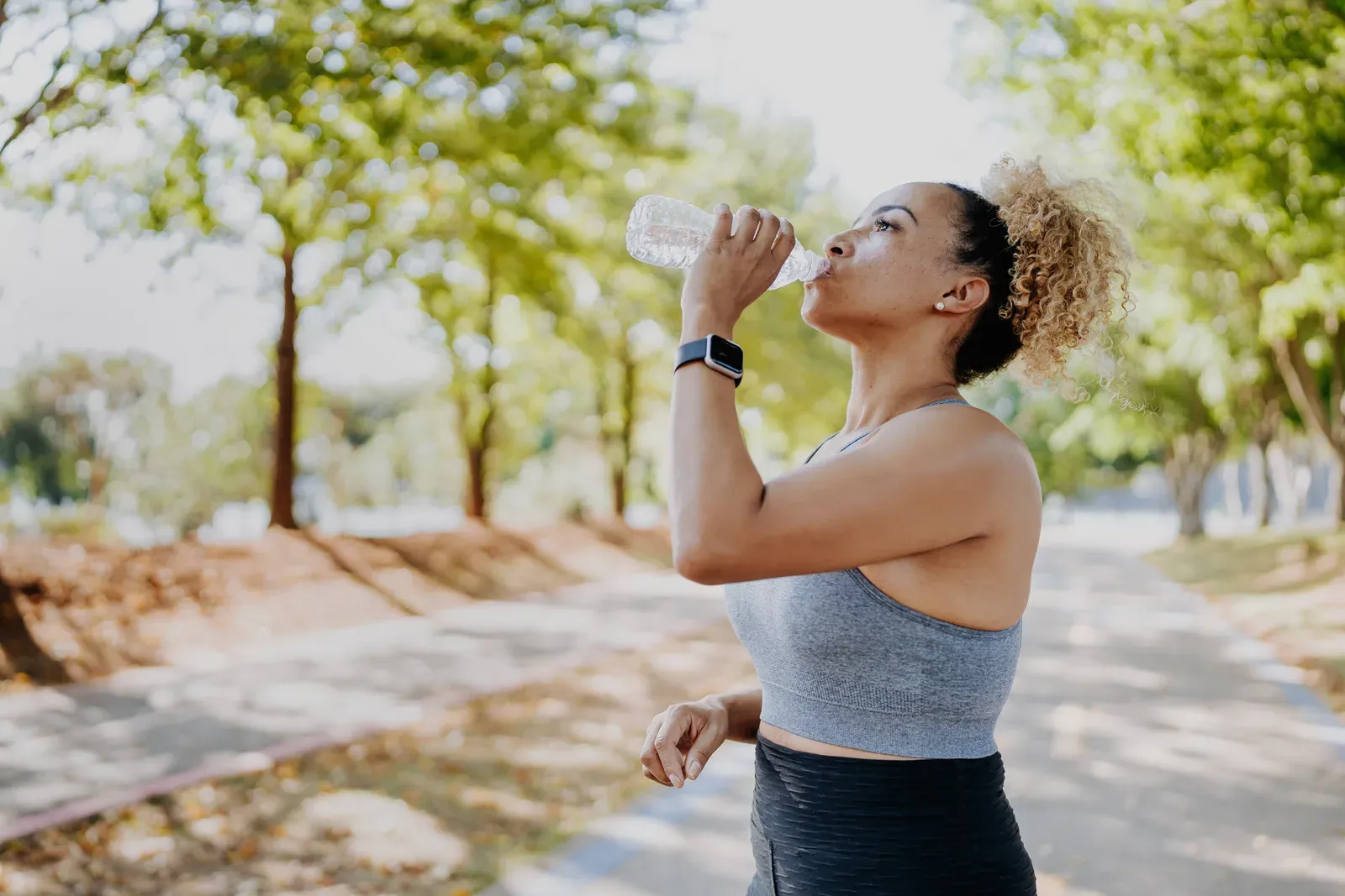 A runner pausing for water on a hot, humid summer morning