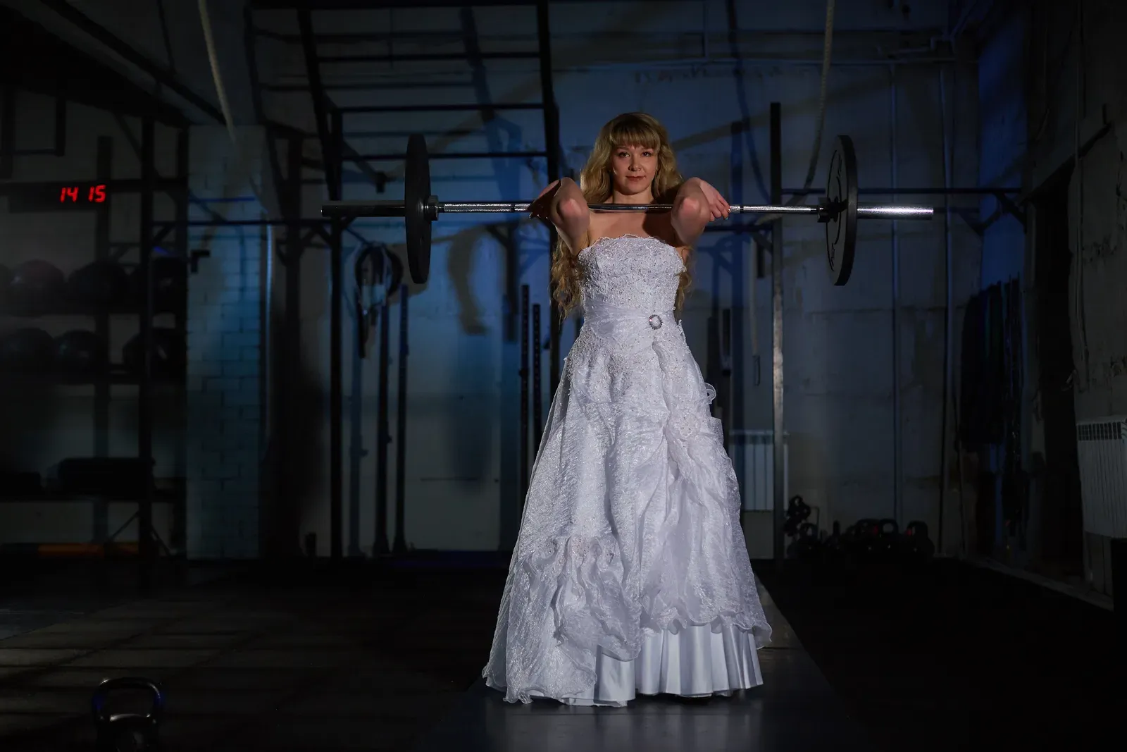 An engaged couple training together with dumbbells in a bright gym