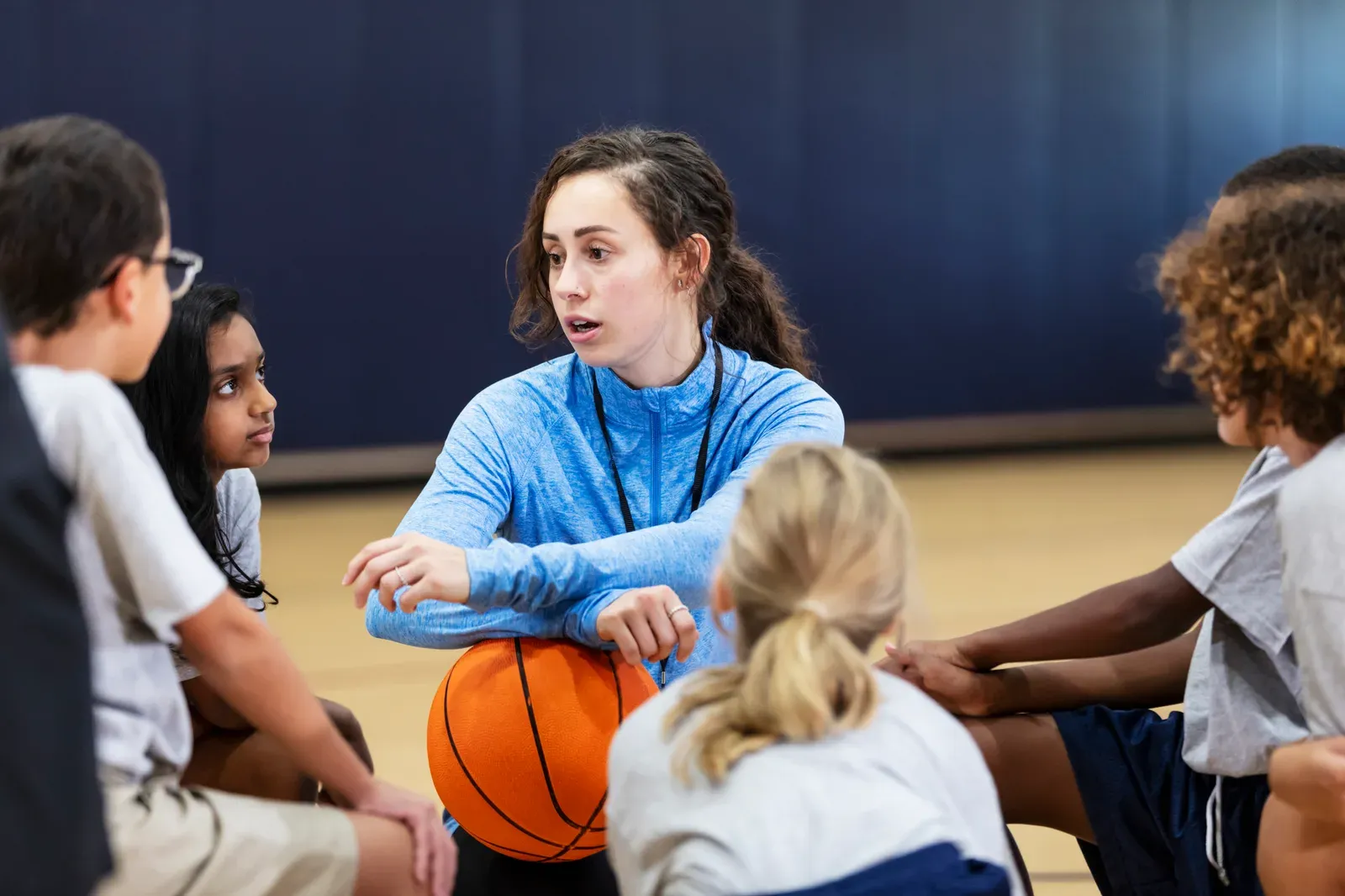Basketball coach giving her young team an encouraging pep talk