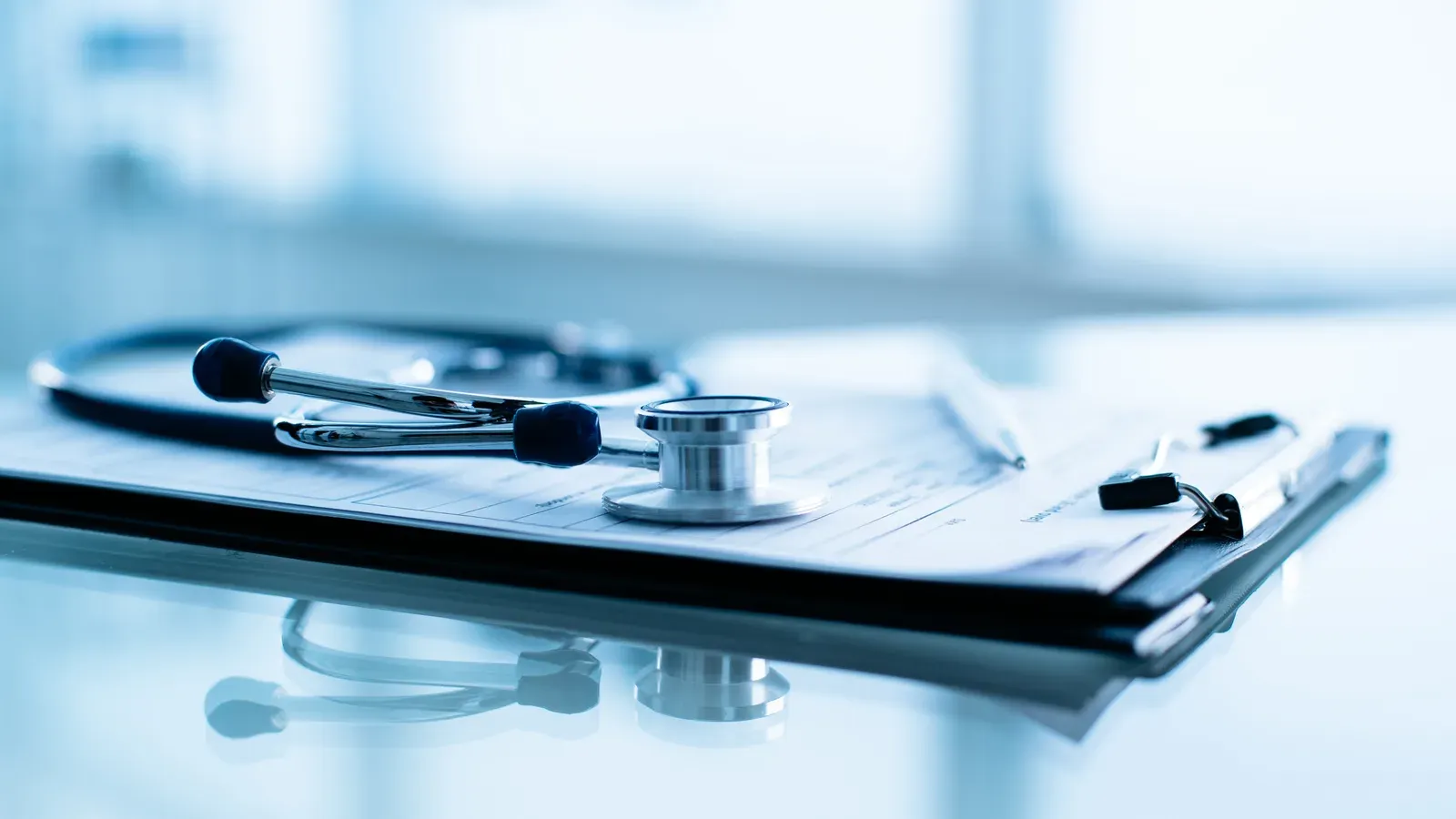 Stethoscope and pen resting on a blank patient health form