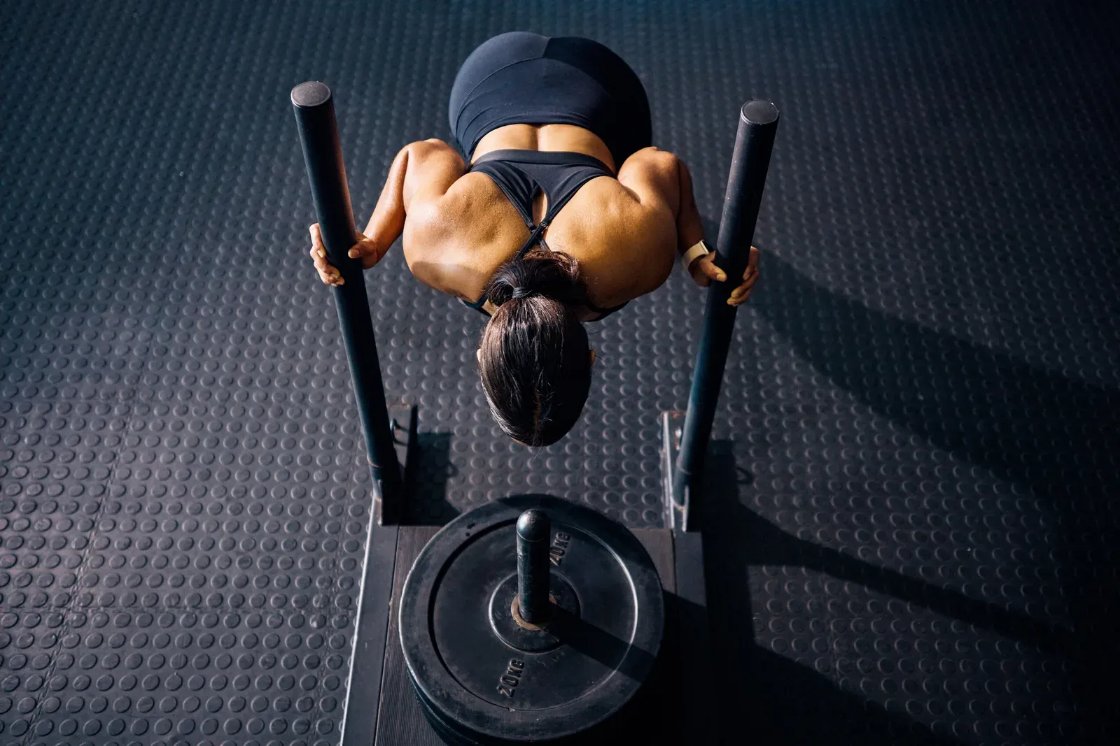 Athletes pushing weighted sleds during an indoor fitness race