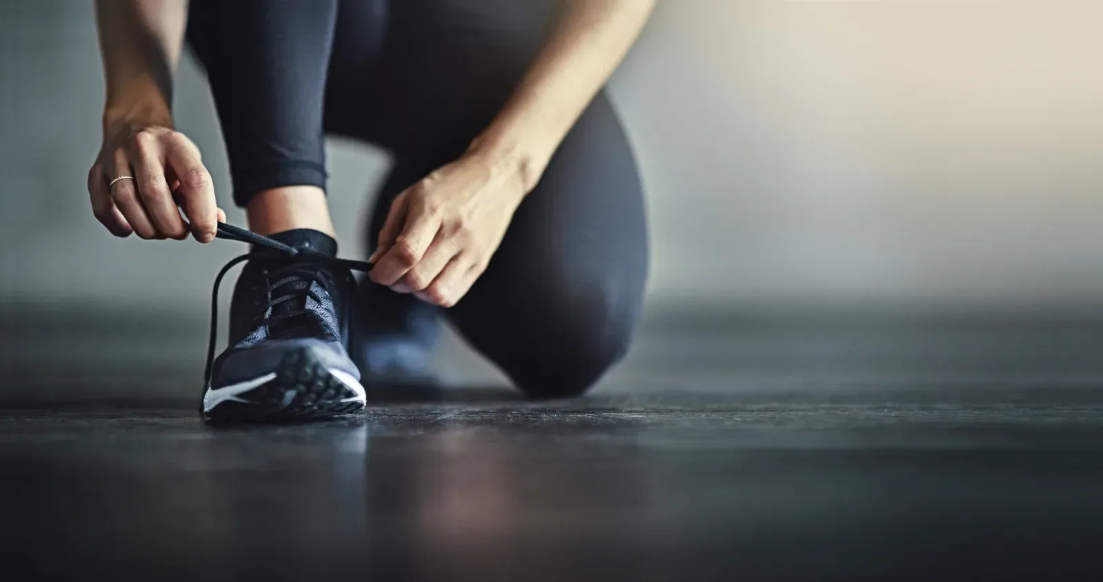 Lacing up athletic shoes while getting ready for a first training session
