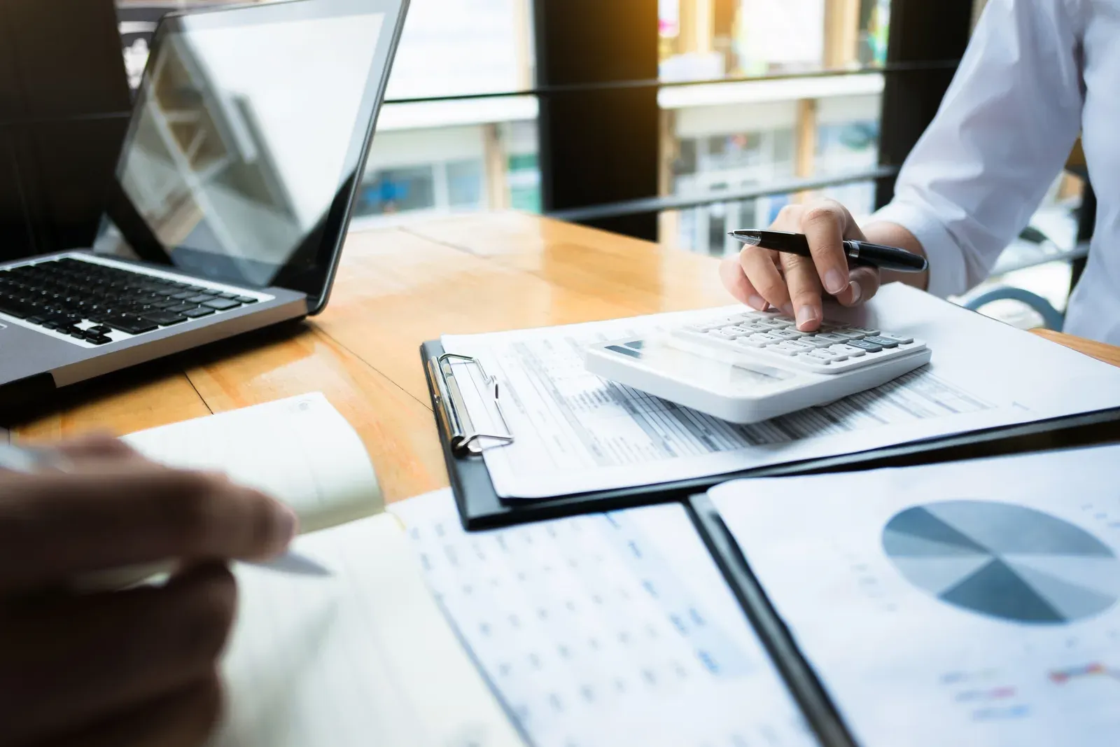 Business audit with a calculator and financial data at a workplace, tracing where a training fee goes