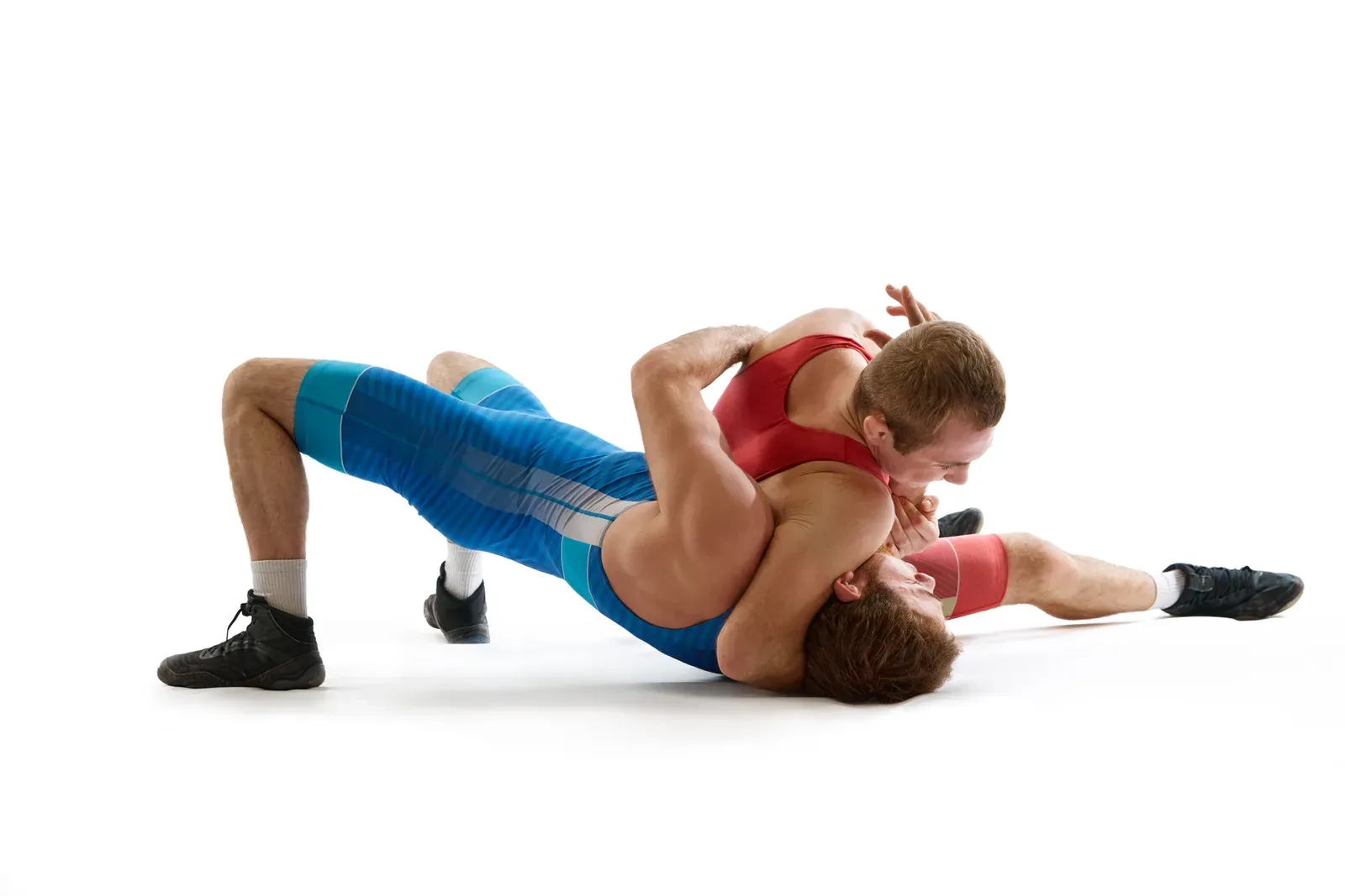 Two wrestlers locked in a tie-up position during a practice match on the mat