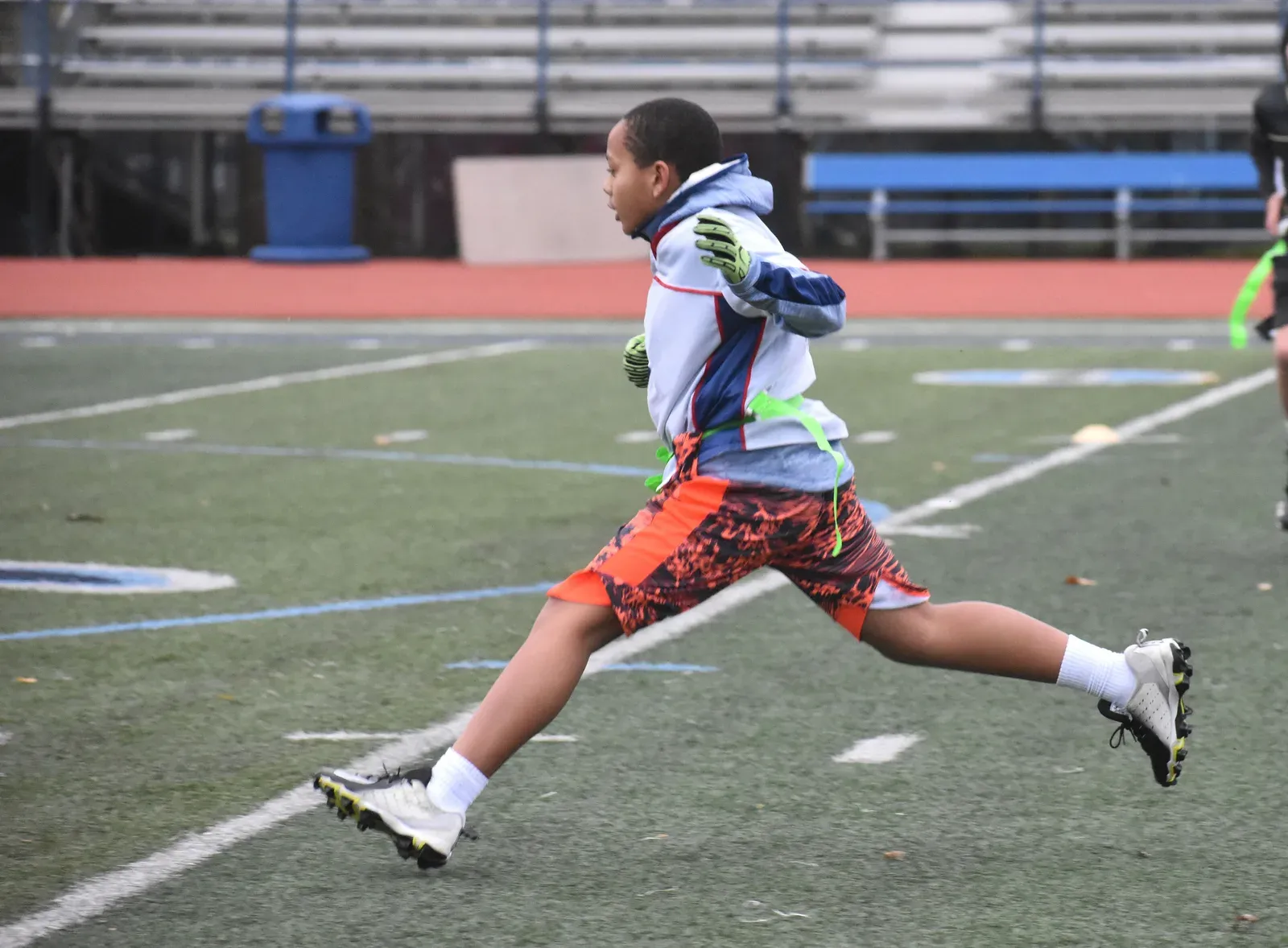 Young athletes sprinting downfield together during a flag football game